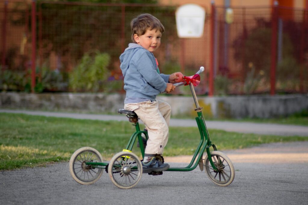 Jeune enfant sur un tricycle dans un parc