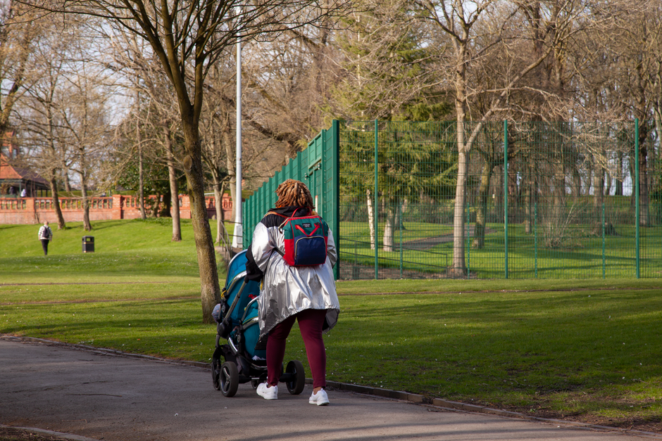 Poussette 3 roues poussée sur un chemin de parc