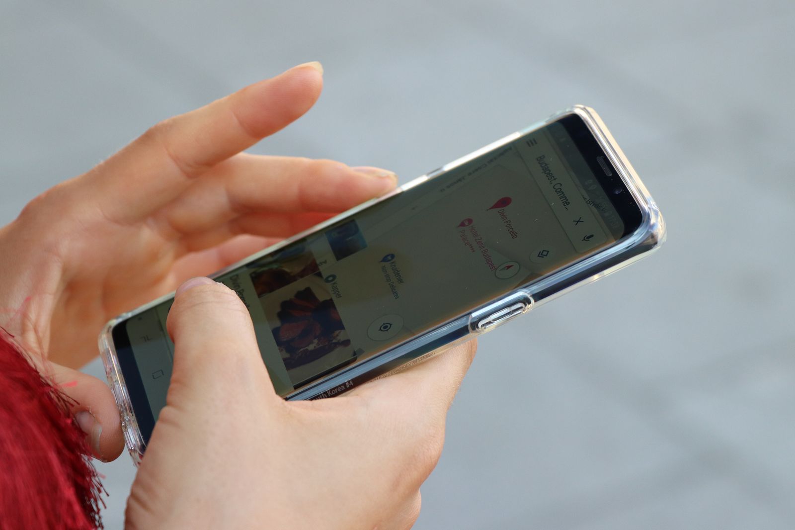 Mains tenant un smartphone qui affiche une carte en plein air
