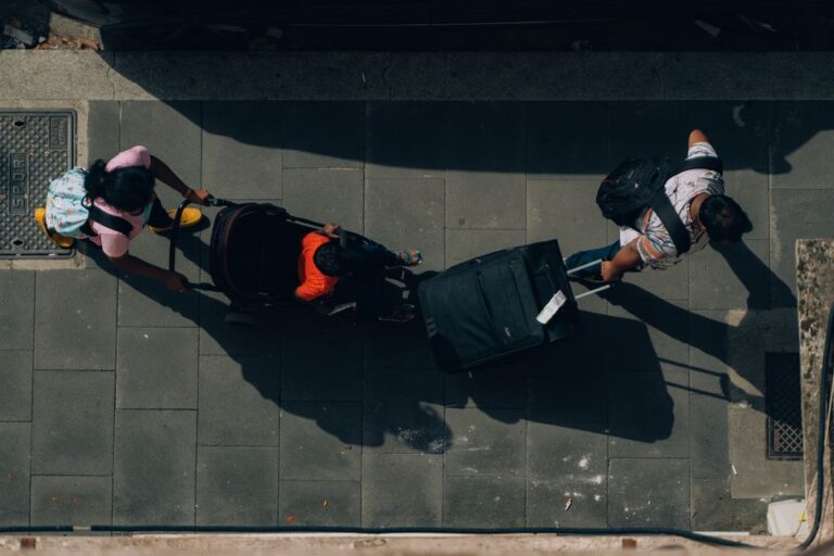 Voyageurs avec valises et poussette compacte en ville