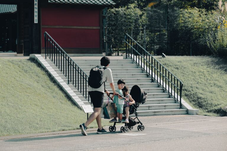 Parent avec une poussette et deux enfants en balade