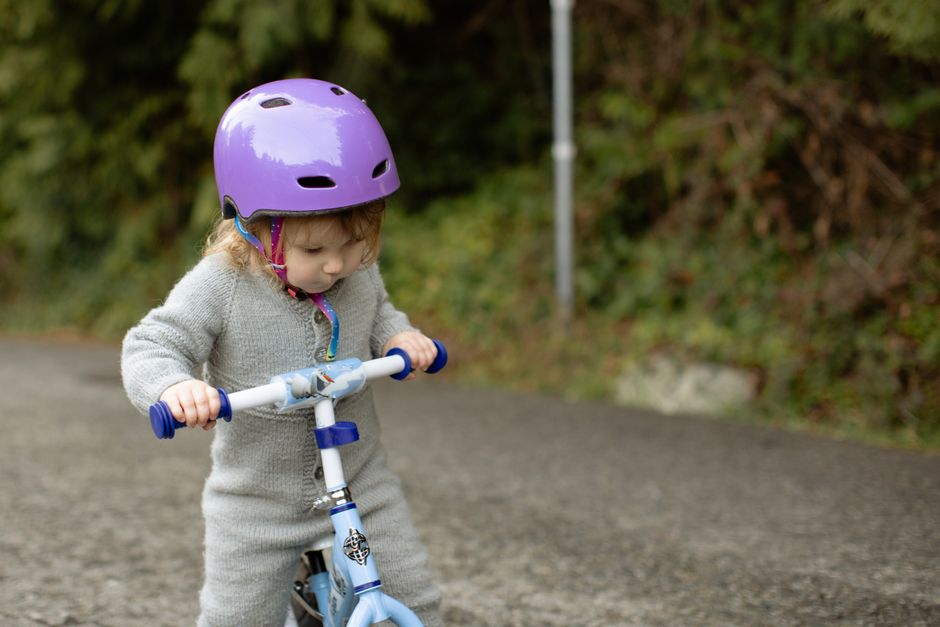 Enfant avec casque sur sa draisienne