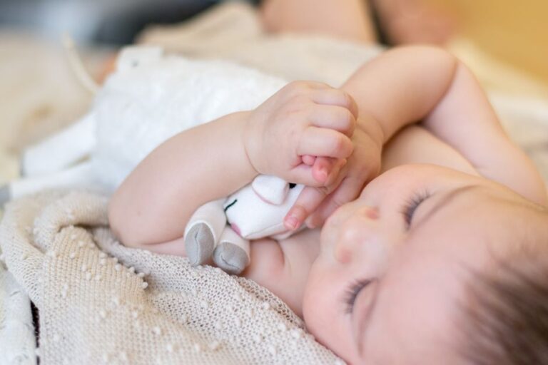 Bébé qui tient son doudou personnalisé