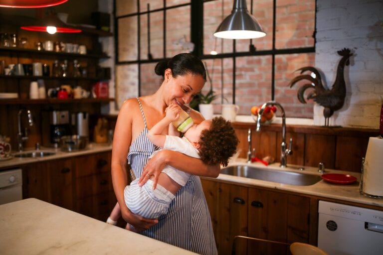 Maman qui donne un biberon à son bébé dans une cuisine