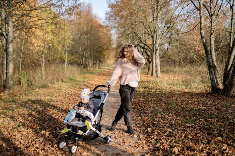 Parent qui pousse une poussette sur un chemin de parc