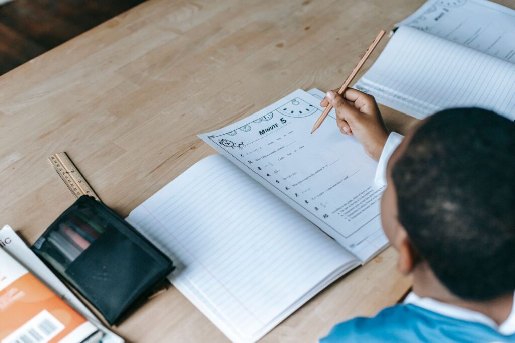 Enfant assis a un bureau en bois pour faire ses devoirs