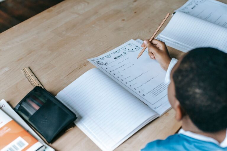 Enfant assis a un bureau en bois pour faire ses devoirs