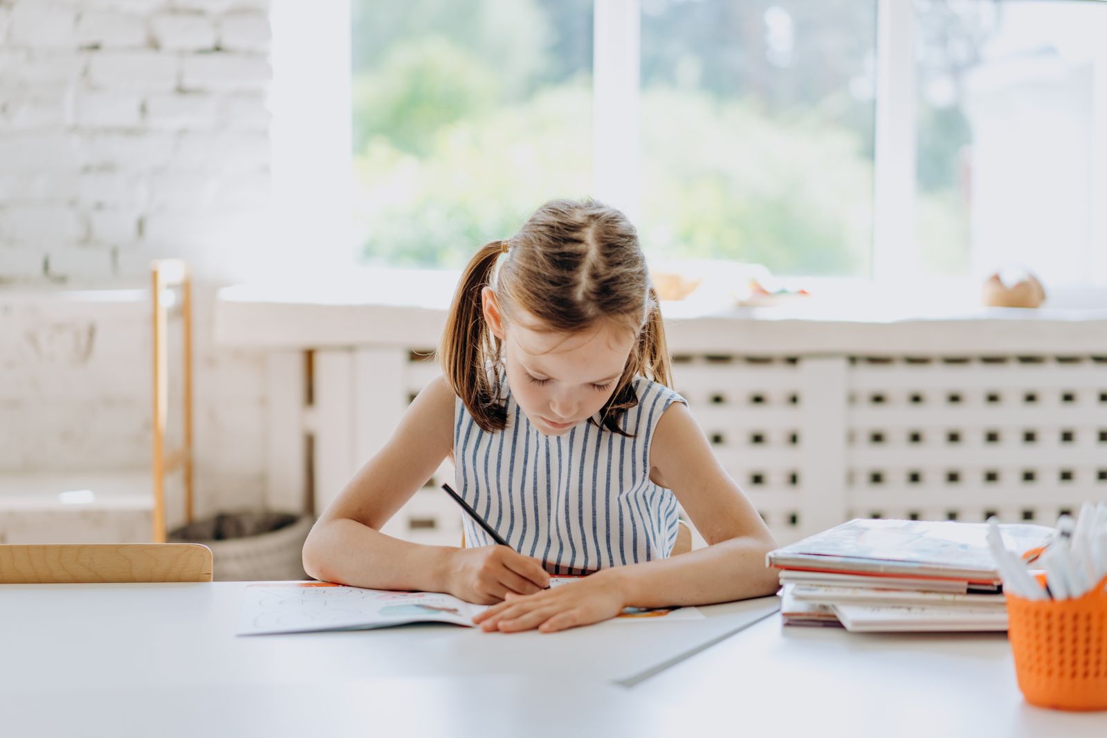 Enfant assis à un petit bureau dans sa chambre