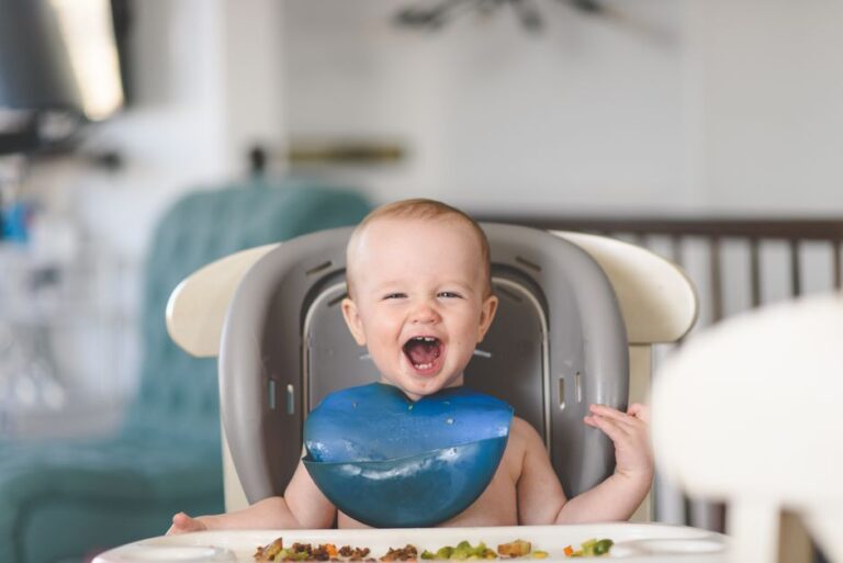 Bébé riant à table pendant le repas